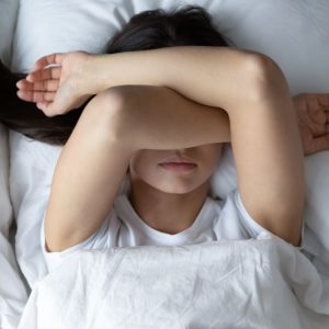 adolescente en la cama con problemas de sueño por efectos psicologicos del covid-19