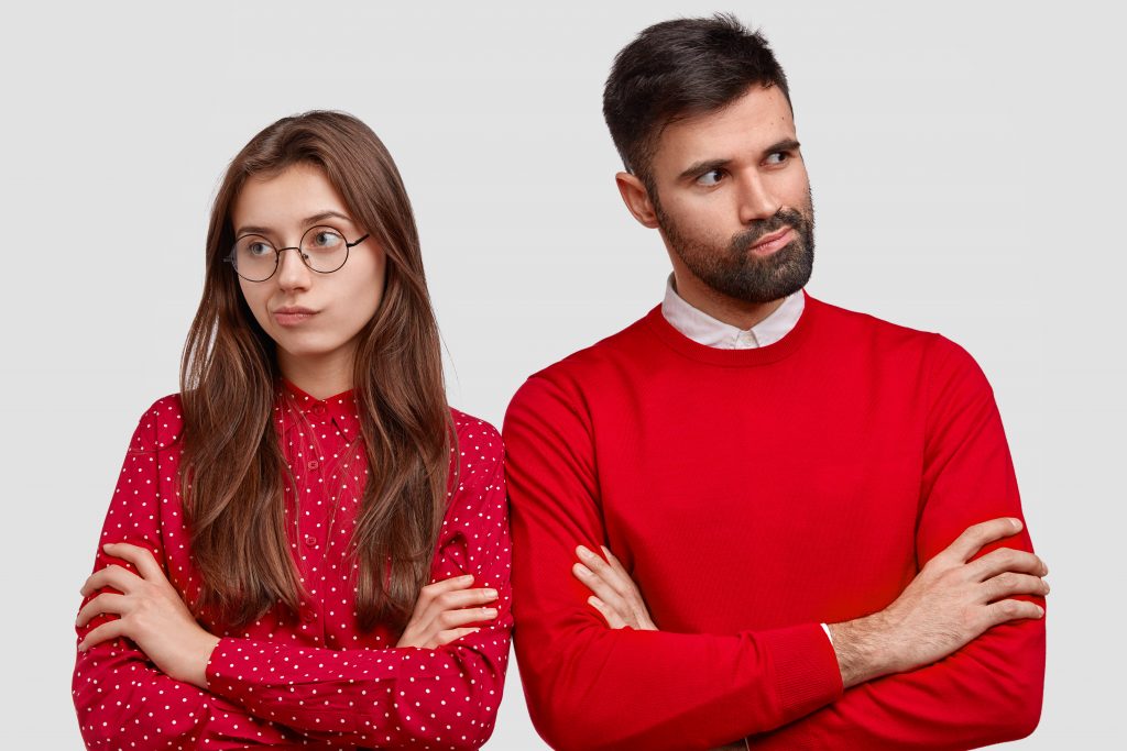 people-love-and-misunderstanding-concept-photo-of-displeased-couple-with-arms-folded-have-fight-wear-red-clothes-scaled - SEPARACIONES O DIVORCIOS DESPUÉS DEL VERANO